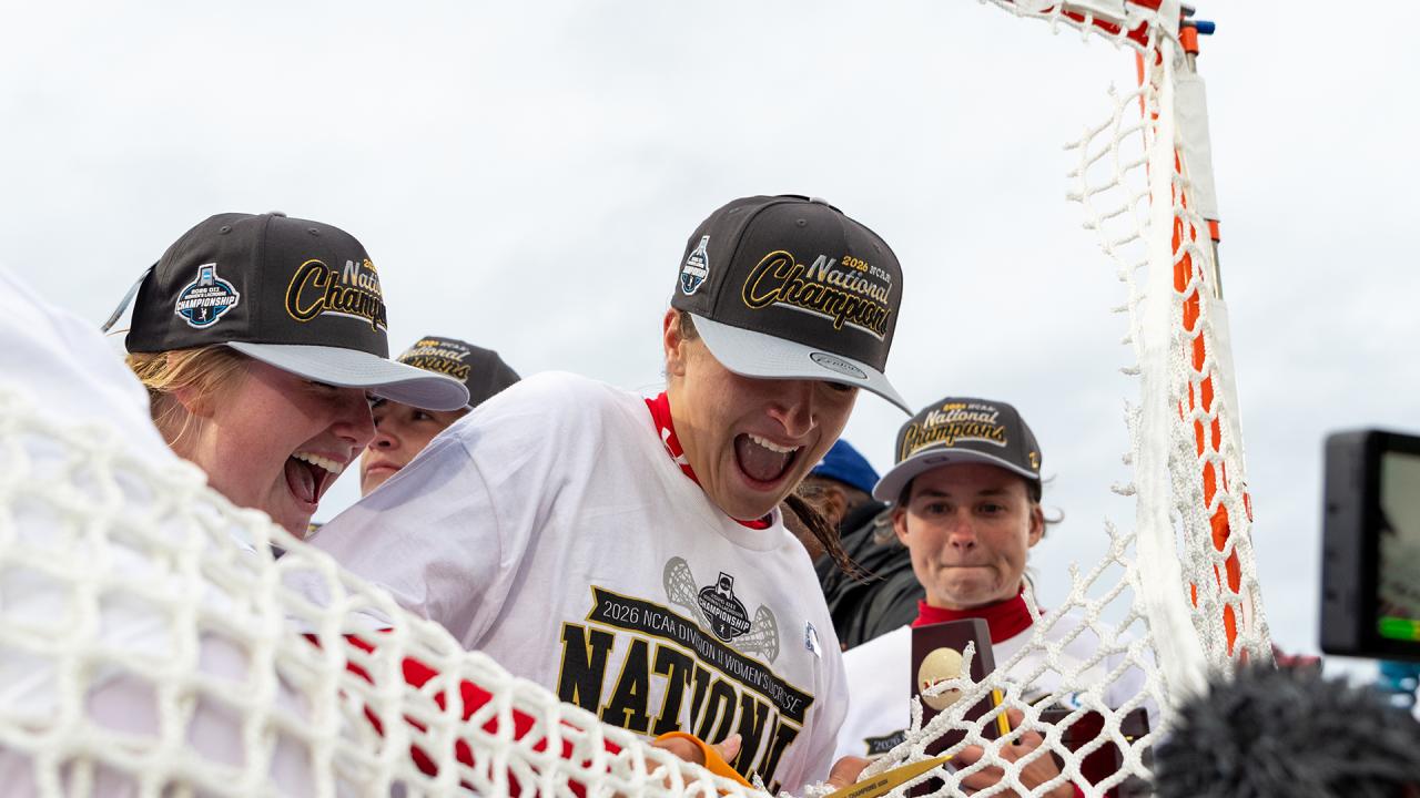Florida Southern women's lacrosse players cut the nets after winning the national championship