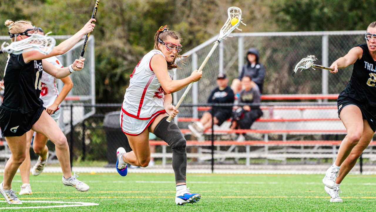 Flagler women's lacrosse player Jessica Wright evades a pair of Anderson defenders