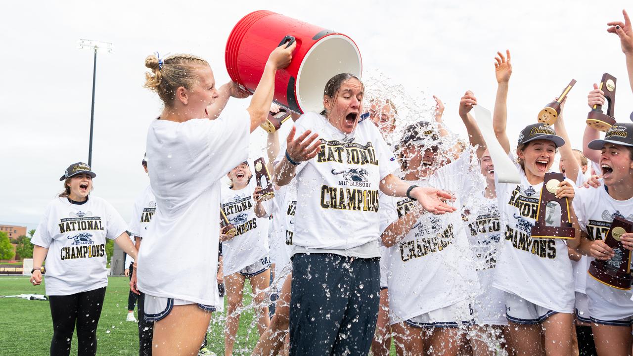 Middlebury head coach Kate Livesay gets drenched with water following the championship win