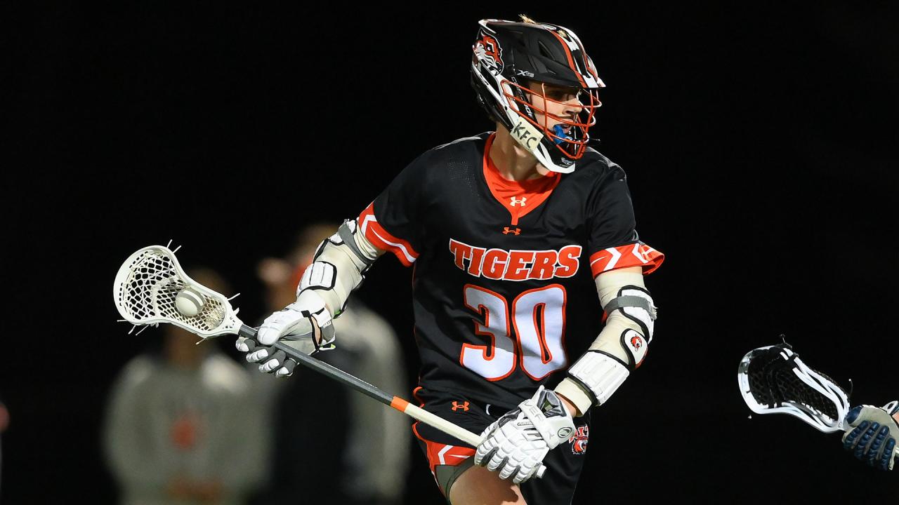 RIT's Ryan Sanders carries the ball during a night lacrosse game