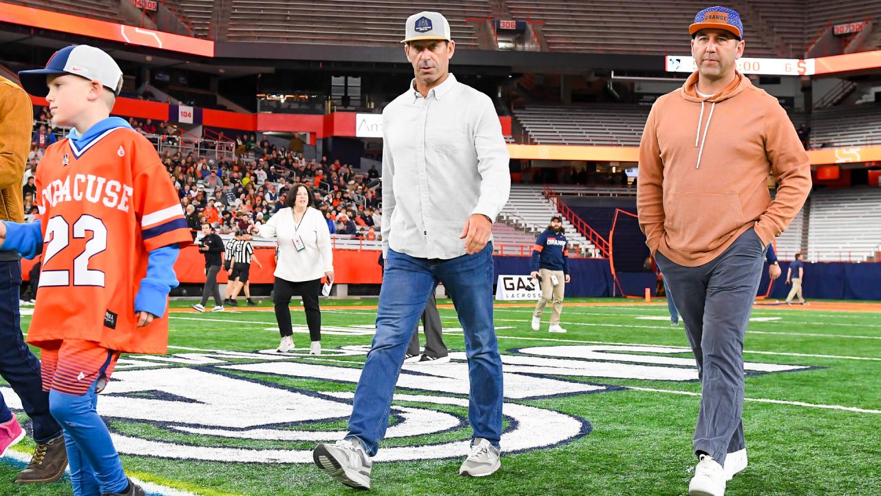 Casey Powell (center) on the field at the JMA Wireless Dome during his brother Mike's jersey retirement in 2023