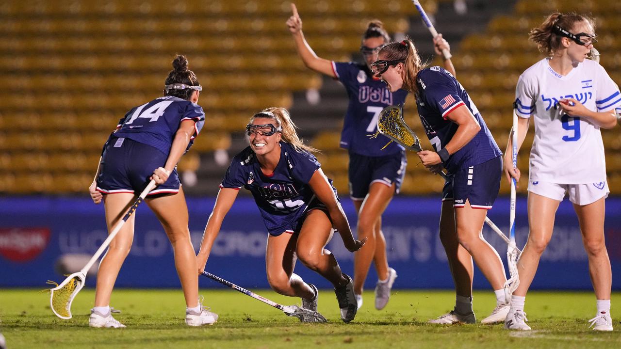 Madison Taylor bends low and celebrates with USA teammates following a goal